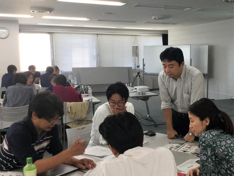 研修で受講者のグループワークに入り助言する梅林行一